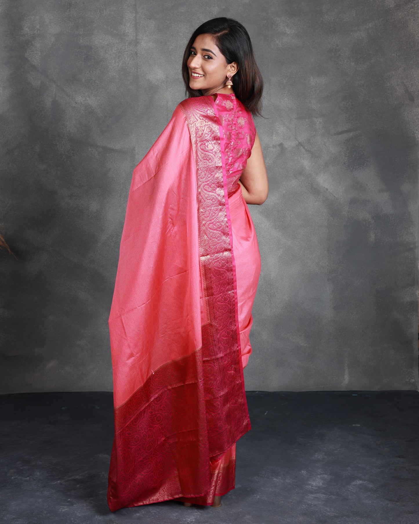 A Pink Saree adorned with a beautiful border