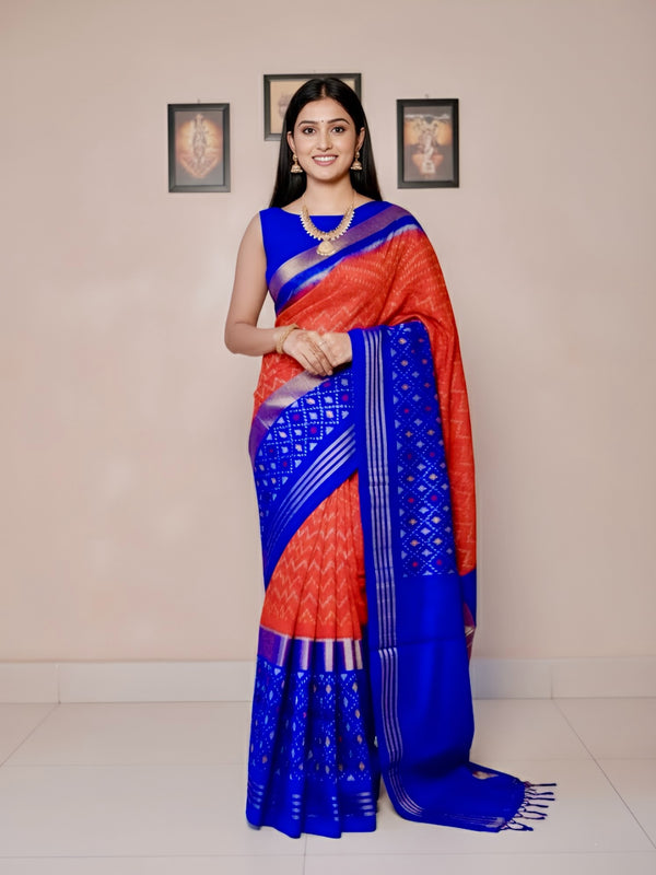 Woman wearing a red and blue saree with a beige background
