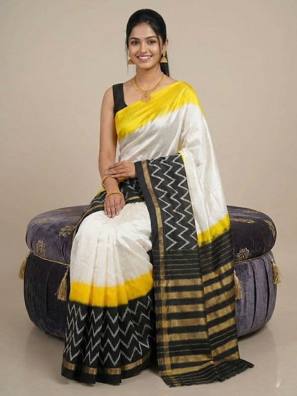 Woman wearing a traditional saree with a white, yellow, and black pattern on a beige background