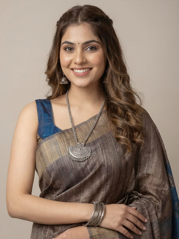 Woman wearing a traditional saree with a neutral background