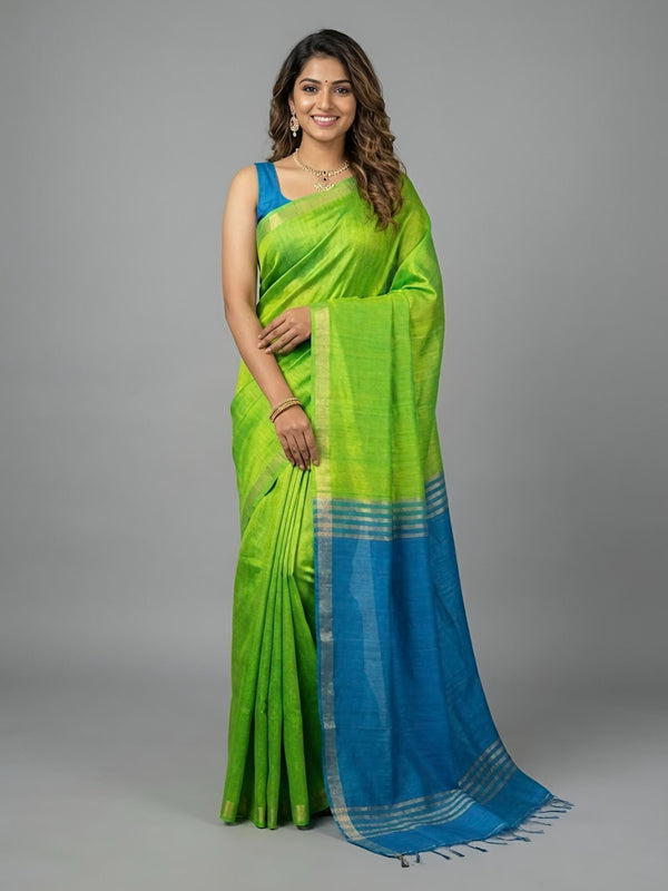 Woman wearing a green and blue saree on a gray background