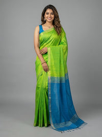 Woman wearing a green and blue saree on a gray background