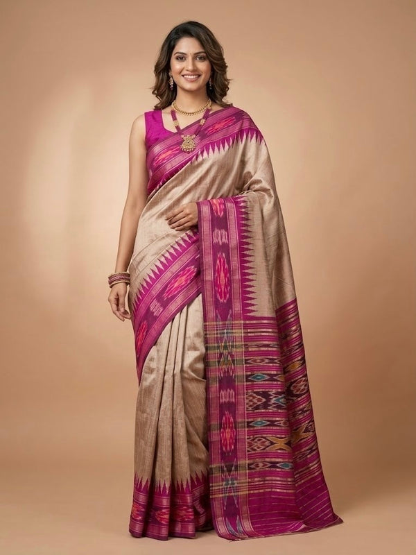 A woman modeling a beige and magenta silk saree with intricate geometric patterns and a matching blouse, set against a solid beige studio background.