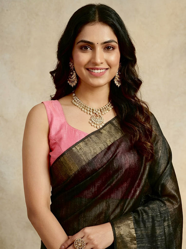 Woman wearing a traditional saree with a pink blouse against a beige background