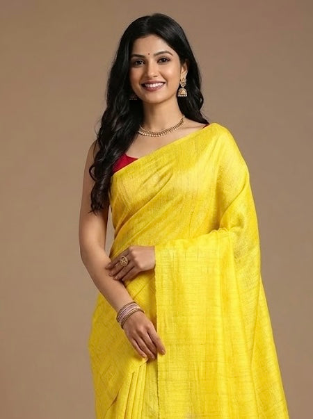 Woman wearing a yellow saree with a plain background
