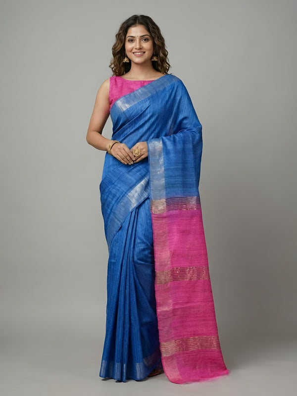 Woman wearing a blue and pink saree on a gray background