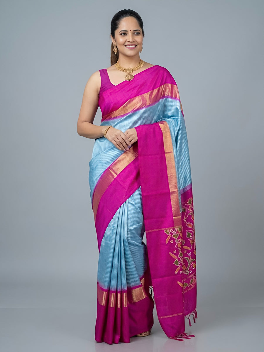 Woman wearing a pink and blue saree with a gray background