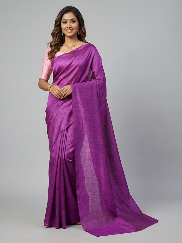 Woman wearing a purple saree with a pink blouse on a gray background